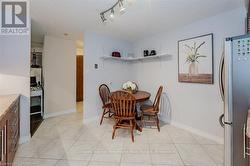 Dining room with track lighting, light tile patterned flooring, a textured ceiling, and baseboards - 