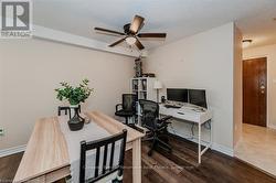 Office space with a textured ceiling, wood finished floors, a ceiling fan, and baseboards - 