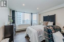 Bedroom featuring baseboard heating, dark wood finished floors, and recessed lighting - 