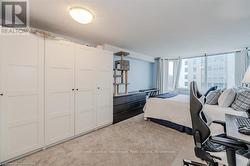 Bedroom featuring a textured ceiling, floor to ceiling windows, a closet, and light colored carpet - 