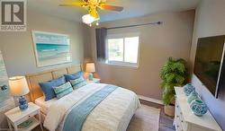 Bedroom with ceiling fan, baseboards, and wood finished floors Virtual Staged - 