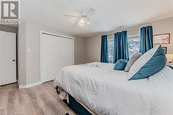 Bedroom featuring ceiling fan, light hardwood / wood-style floors, and a closet - 