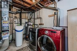 Utility room with washer and clothes dryer and gas water heater - 