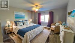 Bedroom with ceiling fan, dark wood-type flooring, and baseboards Virtual Staged - 