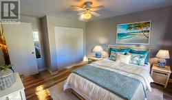 Bedroom featuring a ceiling fan, a closet, baseboards, and wood finished floors Virtual Staged - 