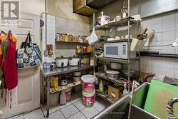 Kitchen with open shelves, white microwave, tile walls, and tasteful backsplash - 