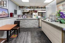 Bar featuring dark wood-type flooring and a paneled ceiling - 