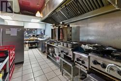 Kitchen with tile patterned floors, custom exhaust hood, and freestanding refrigerator - 