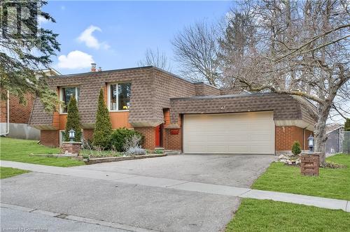 View of front of home featuring a front yard, roof with shingles, brick siding, and mansard roof - 42 Culpepper Drive, Waterloo, ON - Outdoor