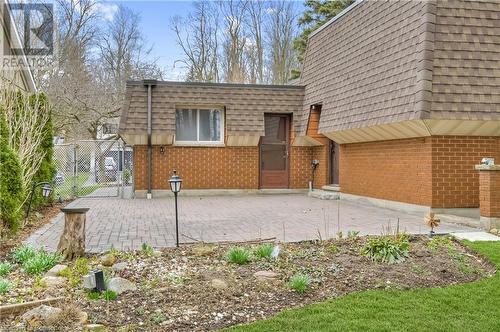 View of front of house featuring a shingled roof, brick siding, and mansard roof - 42 Culpepper Drive, Waterloo, ON - Outdoor