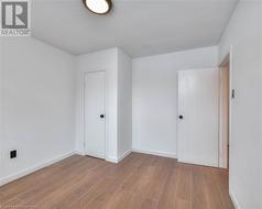 Unfurnished room featuring baseboards and wood finished floors - 