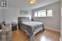 Bedroom with light wood-style floors and baseboards - 