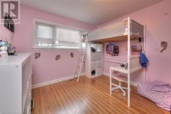 Bedroom with light wood-style flooring and baseboards - 