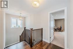 Stairway featuring an inviting chandelier, wood finished floors, and baseboards - 