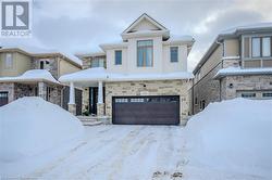 View of front of home with board and batten siding, an attached garage, and stone siding - 