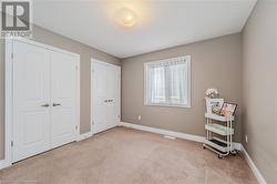 Bedroom with light carpet, visible vents, baseboards, and multiple closets - 