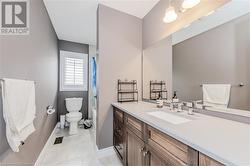 Bathroom featuring vanity, shower / bath combo with shower curtain, toilet, and baseboards - 