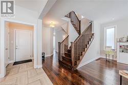 Foyer entrance with visible vents, stairs, baseboards, and wood finished floors - 