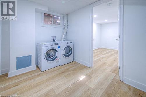 Laundry room featuring wood finished floors, visible vents, baseboards, laundry area, and washer and clothes dryer - 153 Ballantyne Avenue, Cambridge, ON - Indoor Photo Showing Laundry Room