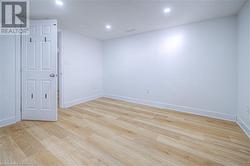 Empty room featuring recessed lighting, baseboards, and light wood finished floors - 