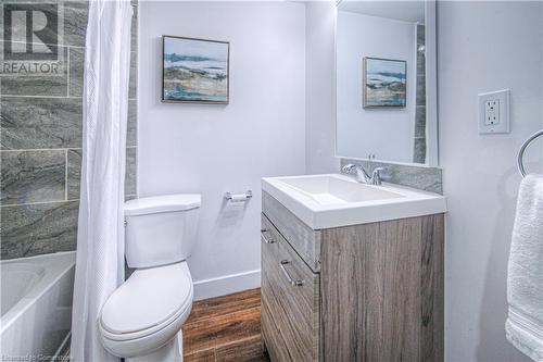 Full bathroom featuring vanity, shower / bathtub combination with curtain, wood finished floors, baseboards, and toilet - 153 Ballantyne Avenue, Cambridge, ON - Indoor Photo Showing Bathroom