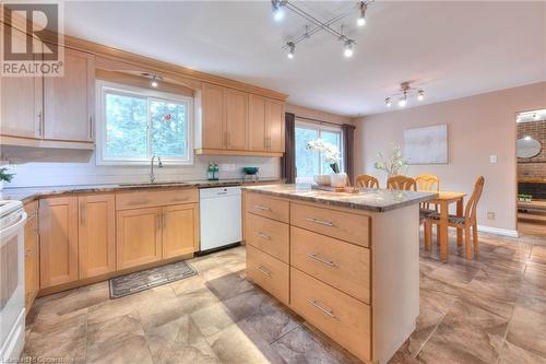 Kitchen with a center island, light brown cabinetry, decorative backsplash, white appliances, and a sink - 105 Sabrina Crescent, Kitchener, ON - Indoor Photo Showing Kitchen