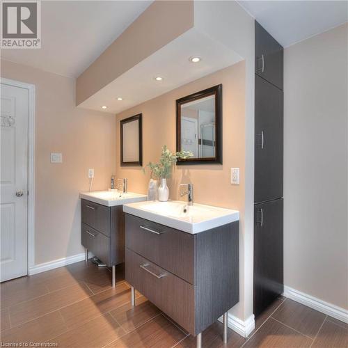 Full bath featuring wood finish floors, baseboards, two vanities, recessed lighting, and a sink - 105 Sabrina Crescent, Kitchener, ON - Indoor Photo Showing Bathroom