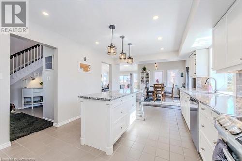 Kitchen featuring a sink, light stone counters, light tile patterned floors, and stainless steel appliances - 598 Coppercroft Court, Waterloo, ON - Indoor Photo Showing Kitchen With Upgraded Kitchen