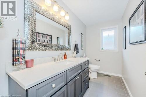 Main floor powder room with tile patterned flooring, baseboards, and vanity - 598 Coppercroft Court, Waterloo, ON - Indoor Photo Showing Bathroom