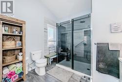 Ensuite with toilet, a stall shower, and vaulted ceiling - 