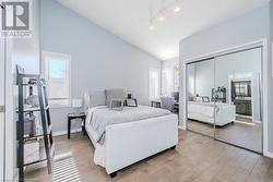 Bedroom with baseboards, multiple windows, high vaulted ceiling, and light wood-style flooring - 