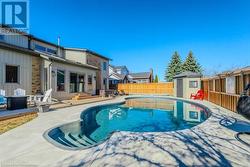 View of swimming pool with a fenced backyard, a shed, an outdoor structure, a fenced in pool, and a patio area - 