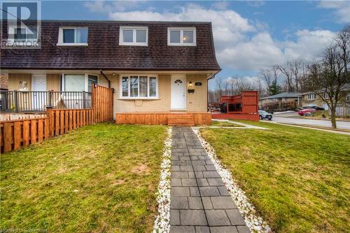 View of front of home with a front lawn, mansard roof, brick siding, and a shingled roof - 55 Ingleside Drive, Kitchener, ON - Outdoor With Deck Patio Veranda