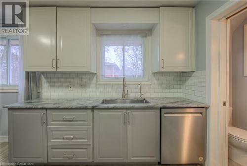 Kitchen featuring a sink, decorative backsplash, stainless steel dishwasher, and white cabinets - 55 Ingleside Drive, Kitchener, ON - Indoor Photo Showing Kitchen