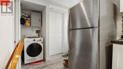 Washroom with washer / dryer, laundry area, and light wood finished floors - 