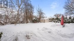 Yard layered in snow with a storage shed and an outbuilding - 