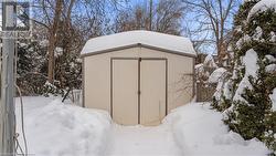 Snow covered structure featuring an outbuilding and a storage unit - 