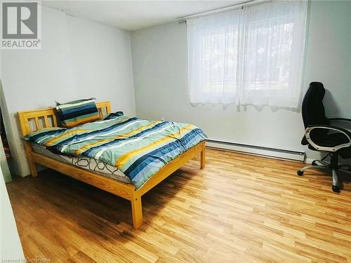 Bedroom with baseboard heating and wood finished floors - 212 Westcourt Place, Waterloo, ON - Indoor Photo Showing Bedroom