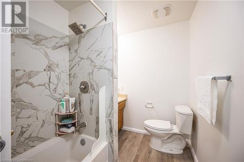 Bathroom with shower / tub combination, toilet, wood finished floors, vanity, and baseboards - 212 Westcourt Place, Waterloo, ON - Indoor Photo Showing Bathroom