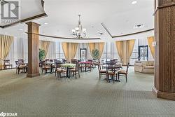 Carpeted dining room with ornate columns, visible vents, and a raised ceiling - 