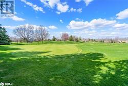 Surrounding community with view of golf course and a yard - 