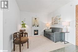 Living area featuring carpet, a glass covered fireplace, and baseboards - 