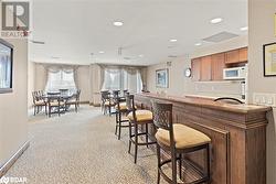 Kitchen with baseboards, visible vents, light colored carpet, white microwave, and recessed lighting - 