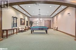 Game room with baseboards, pool table, light colored carpet, and crown molding - 