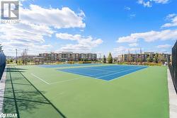 View of tennis court with community basketball court and fence - 