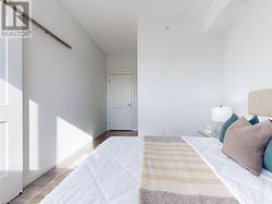 Bedroom featuring a barn door and wood finished floors - 