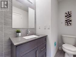 Bathroom with tile patterned flooring, baseboards, vanity, and toilet - 