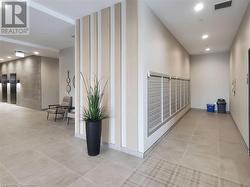 Hallway featuring visible vents, elevator, mail area, light tile patterned flooring, and recessed lighting - 