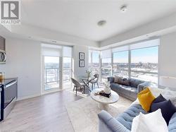 Living room featuring visible vents, baseboards, a city view, and light wood finished floors - 