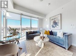 Living room featuring floor to ceiling windows, visible vents, and wood finished floors - 